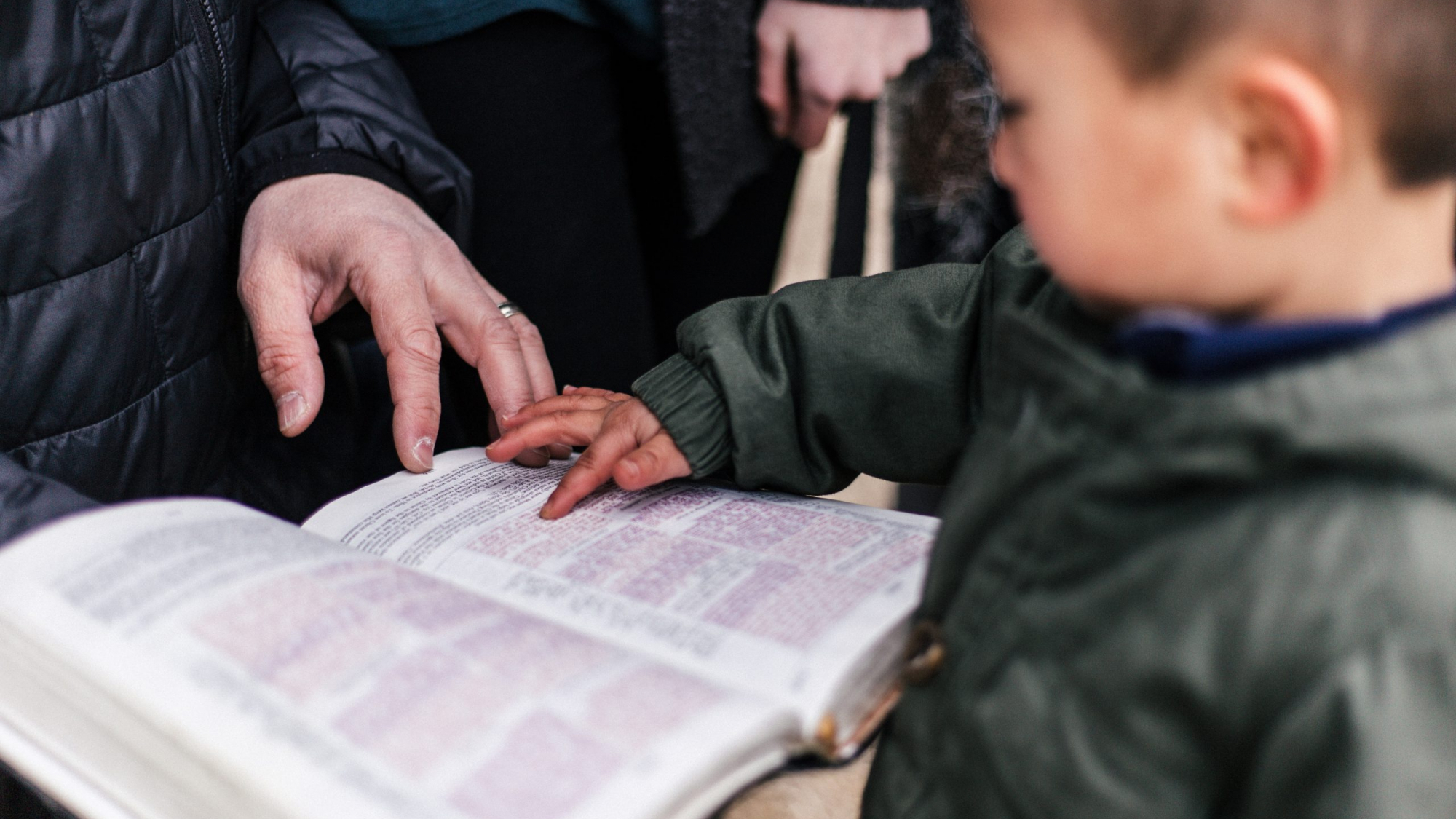 boy touching page of book