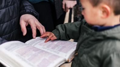 boy touching page of book