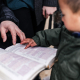 boy touching page of book